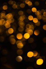 Obraz premium Abstract pattern of golden bokeh garland lights on a dark background