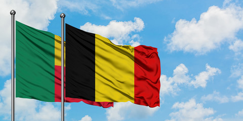 Benin and Belgium flag waving in the wind against white cloudy blue sky together. Diplomacy concept, international relations.