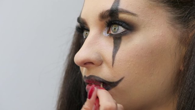 Easy Halloween Makeup. Applying makeup to the face. The black outline of the contour of the lips.