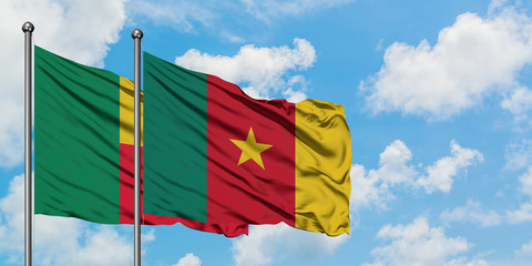 Benin and Cameroon flag waving in the wind against white cloudy blue sky together. Diplomacy concept, international relations.