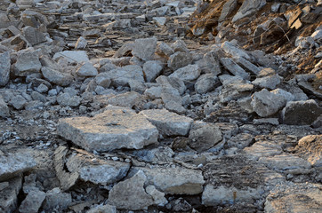 Recycling and reuse crushed concrete rubble, asphalt, building material, blocks. Broken concrete slabs at construction site. Сoncrete rubble from demolition at landfill. Hardcore waste recycling