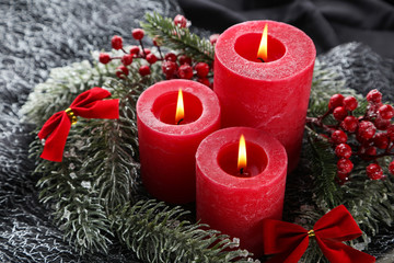 Obraz na płótnie Canvas Christmas candles with red berries and fir tree branches