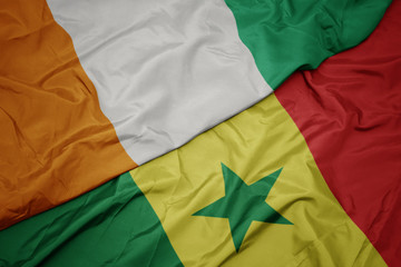 waving colorful flag of senegal and national flag of cote divoire.