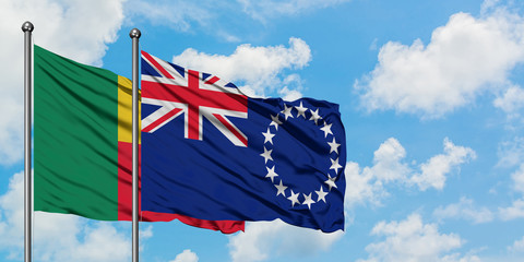 Benin and Cook Islands flag waving in the wind against white cloudy blue sky together. Diplomacy...