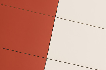 Geometric color elements of the building's facade with planes, lines, corners with highlights and reflections for an abstract background and texture of red, orange colors. Place for text