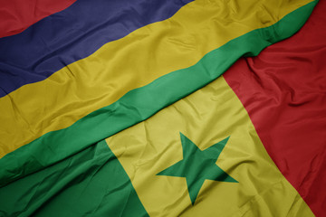 waving colorful flag of senegal and national flag of mauritius.