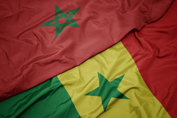 waving colorful flag of senegal and national flag of morocco.