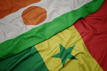 waving colorful flag of senegal and national flag of niger.
