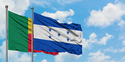 Benin and Honduras flag waving in the wind against white cloudy blue sky together. Diplomacy...