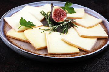 raclette cheese sliced. Very delicious swiss raclette on rustic background