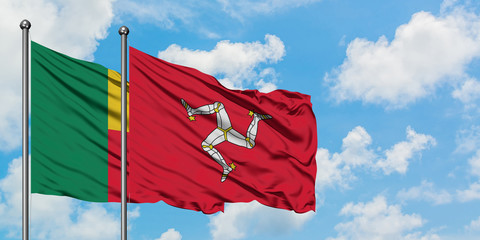 Benin and Isle Of Man flag waving in the wind against white cloudy blue sky together. Diplomacy concept, international relations.
