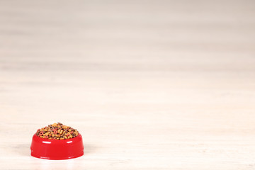 Dry pet food in bowl on the floor