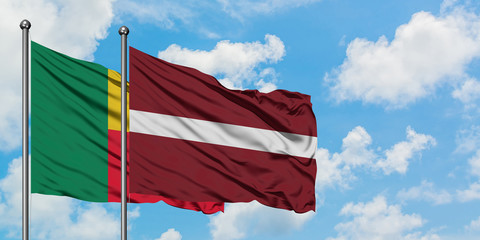 Benin and Latvia flag waving in the wind against white cloudy blue sky together. Diplomacy concept, international relations.