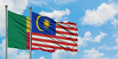 Benin and Malaysia flag waving in the wind against white cloudy blue sky together. Diplomacy concept, international relations.