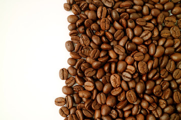 Dark brown roasted coffee beans isolated on white background with copy space