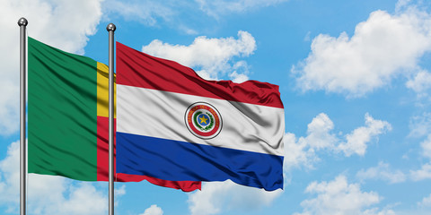 Benin and Paraguay flag waving in the wind against white cloudy blue sky together. Diplomacy concept, international relations.