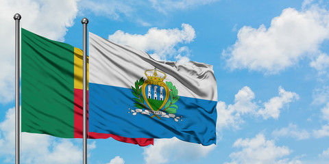 Benin and San Marino flag waving in the wind against white cloudy blue sky together. Diplomacy concept, international relations.