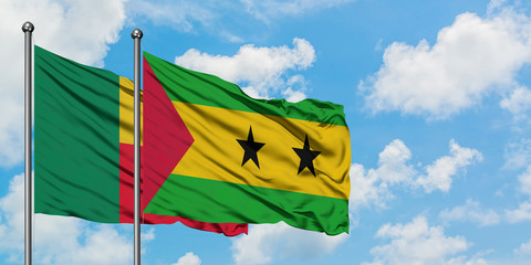 Benin and Sao Tome And Principe flag waving in the wind against white cloudy blue sky together. Diplomacy concept, international relations.
