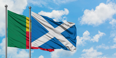 Benin and Scotland flag waving in the wind against white cloudy blue sky together. Diplomacy concept, international relations.