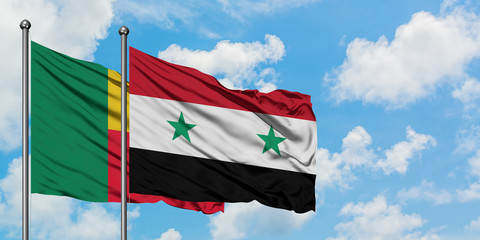 Benin and Syria flag waving in the wind against white cloudy blue sky together. Diplomacy concept, international relations.