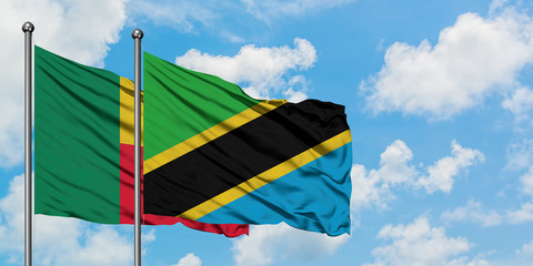 Benin and Tanzania flag waving in the wind against white cloudy blue sky together. Diplomacy...