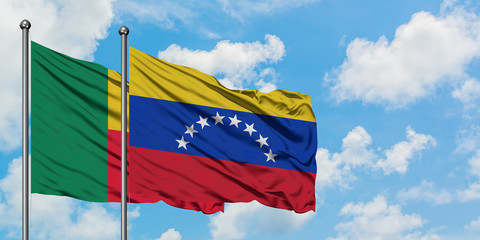 Benin and Venezuela flag waving in the wind against white cloudy blue sky together. Diplomacy concept, international relations.