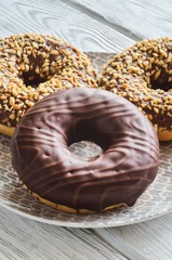 Sweet delicious dessert. Donut with a hole and with chocolate coating and nuts.