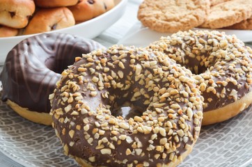 Sweet delicious dessert. Donut with a hole and with chocolate coating and nuts.