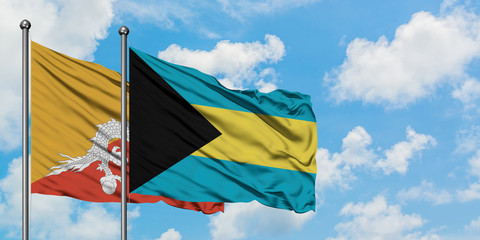 Bhutan and Bahamas flag waving in the wind against white cloudy blue sky together. Diplomacy concept, international relations.