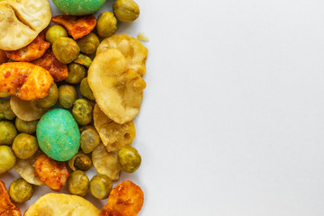 Japanese spicy snacks with peanuts and wasabi are on the left on a white background, on the right is an empty place