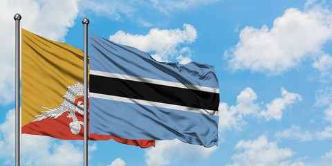 Bhutan and Botswana flag waving in the wind against white cloudy blue sky together. Diplomacy concept, international relations.