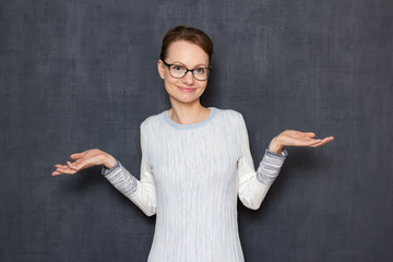 Portrait of happy woman stretching hands and shrugging shoulders