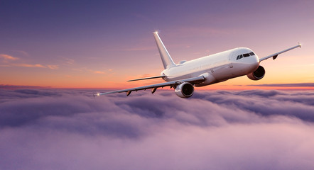 Fototapeta na wymiar Commercial airplane flying above dramatic clouds during sunset.