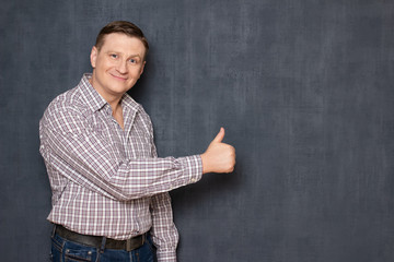Portrait of happy satisfied man showing thumb up gesture