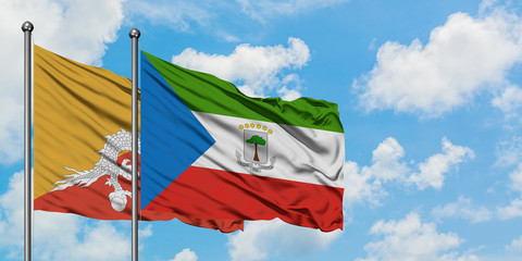 Bhutan and Equatorial Guinea flag waving in the wind against white cloudy blue sky together. Diplomacy concept, international relations.