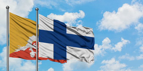 Bhutan and Finland flag waving in the wind against white cloudy blue sky together. Diplomacy concept, international relations.