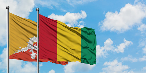 Bhutan and Guinea flag waving in the wind against white cloudy blue sky together. Diplomacy concept, international relations.