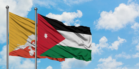 Bhutan and Jordan flag waving in the wind against white cloudy blue sky together. Diplomacy concept, international relations.