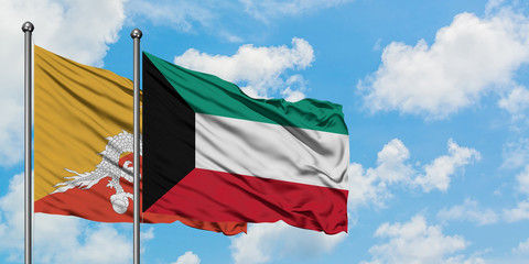 Bhutan and Kuwait flag waving in the wind against white cloudy blue sky together. Diplomacy concept, international relations.