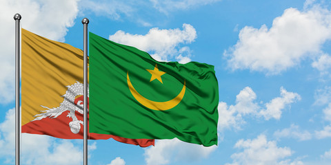 Bhutan and Mauritania flag waving in the wind against white cloudy blue sky together. Diplomacy concept, international relations.