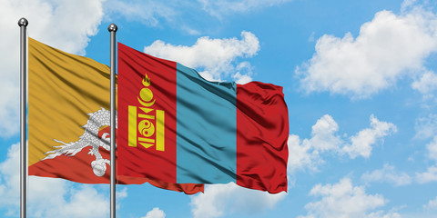 Bhutan and Mongolia flag waving in the wind against white cloudy blue sky together. Diplomacy concept, international relations.