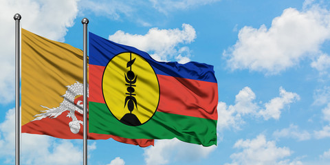 Bhutan and New Caledonia flag waving in the wind against white cloudy blue sky together. Diplomacy concept, international relations.