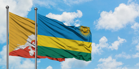 Bhutan and Rwanda flag waving in the wind against white cloudy blue sky together. Diplomacy concept, international relations.