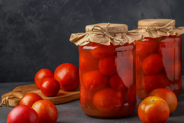 Homemade salted tomatoes in jars on a dark background, Fermented food, closeup