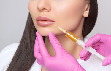 Cosmetologist does prp therapy from wrinkles on the face of a woman in a beauty salon.Cosmetology...