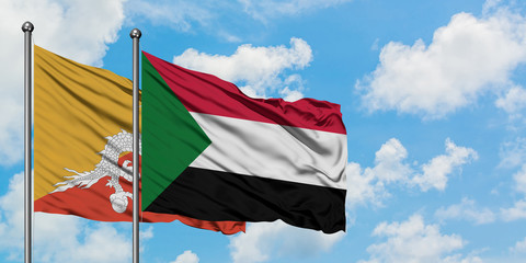 Bhutan and Sudan flag waving in the wind against white cloudy blue sky together. Diplomacy concept, international relations.
