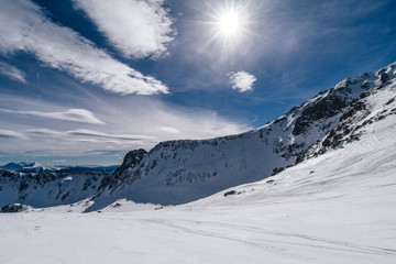 Beautiful winter alpine mountain landscape of Niedere Tauern. Alpine landscape covered with snow, high alpine peaks near Hohetauern ski resort, Austria. Mountains in winter, blue sky, ski touring.