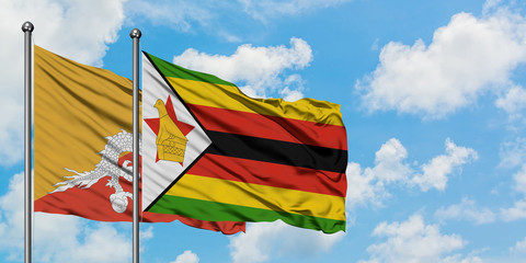Bhutan and Zimbabwe flag waving in the wind against white cloudy blue sky together. Diplomacy concept, international relations.