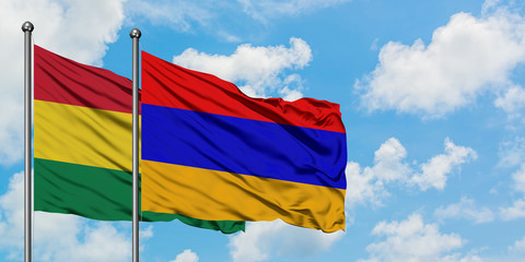 Bolivia and Armenia flag waving in the wind against white cloudy blue sky together. Diplomacy concept, international relations.