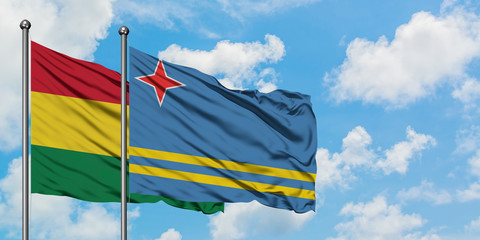 Bolivia and Aruba flag waving in the wind against white cloudy blue sky together. Diplomacy concept, international relations.